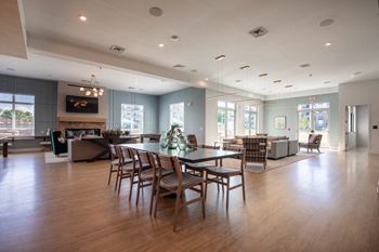A large dining room and living room with a table and chairs